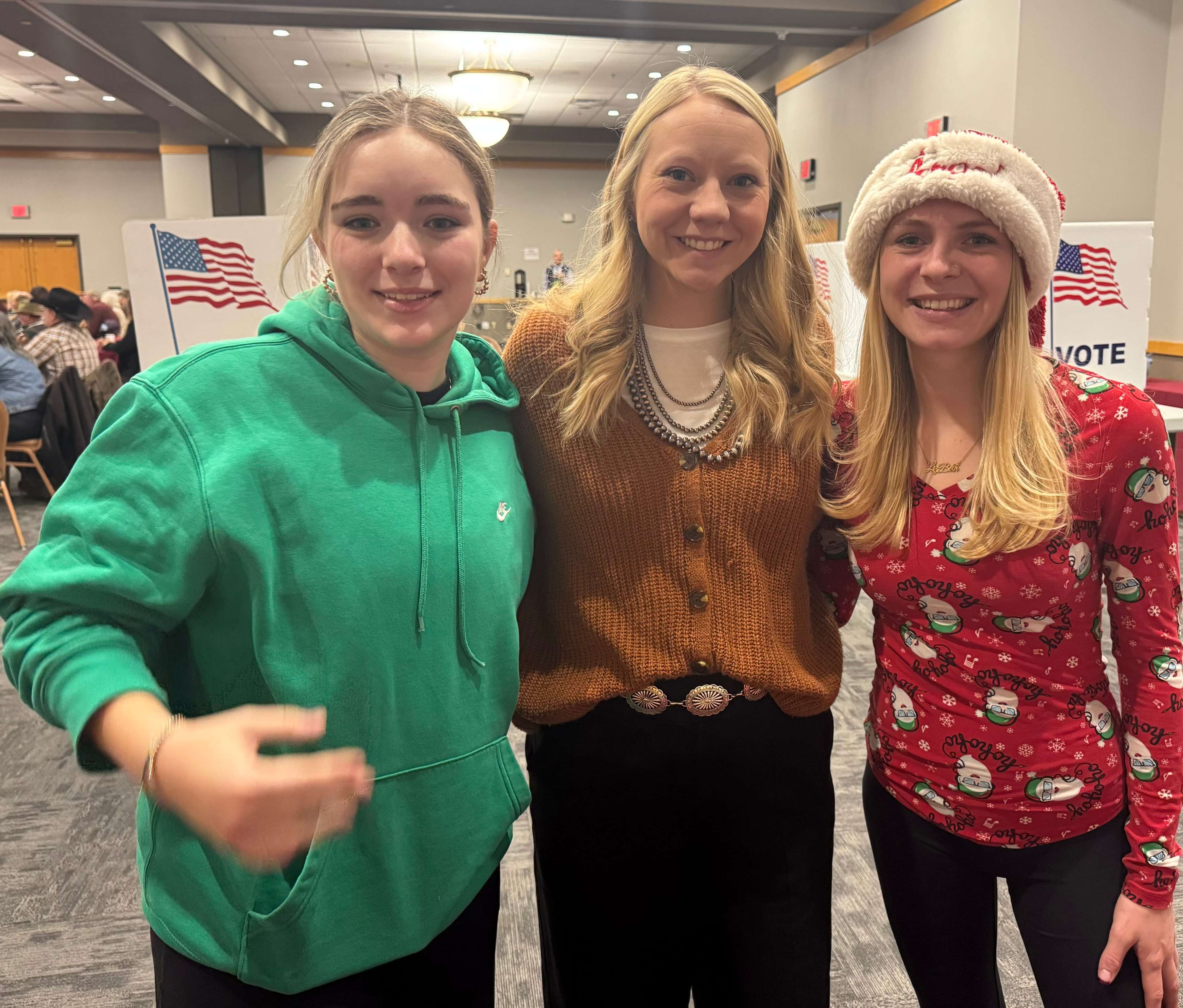 Three young women at the event with American flags in background