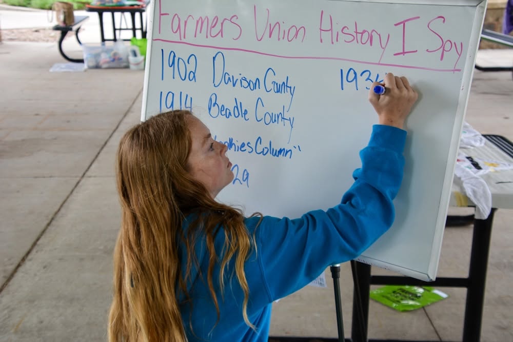 Youth participant writing Farmers Union history on a whiteboard
